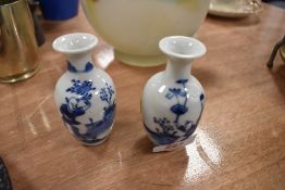 A pair of bud vases having Chinese design in blue to white ground.