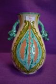 A colourful piece of art pottery having mythical beasts forming the two handles,initialled EW to