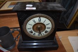 A Victorian Jet black metal cased mantle clock AF with ormolu and enamel face