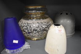 A collection of vintage lamp shades including two industrial metal shades and three of blue glass.