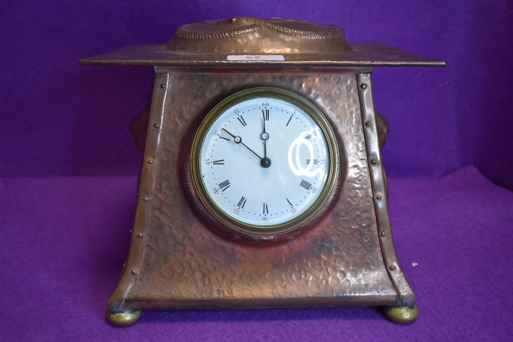 An arts and crafts hammered copper and brass mantel clock having embossed snake to top, another