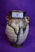 A Crown Devon vase having intricate pattern of flowers, dragon fly and spider in web, hand painted