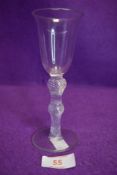 An antique wine glass having bell shaped bowl and multi spiral air twists to stem surrounded by