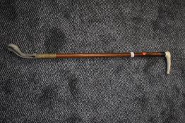 A long horn handled riding crop having sterling silver cuff to neck.