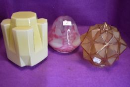 Three art deco glass lamp shades, one of mottled pink and white and another in yellow with angular