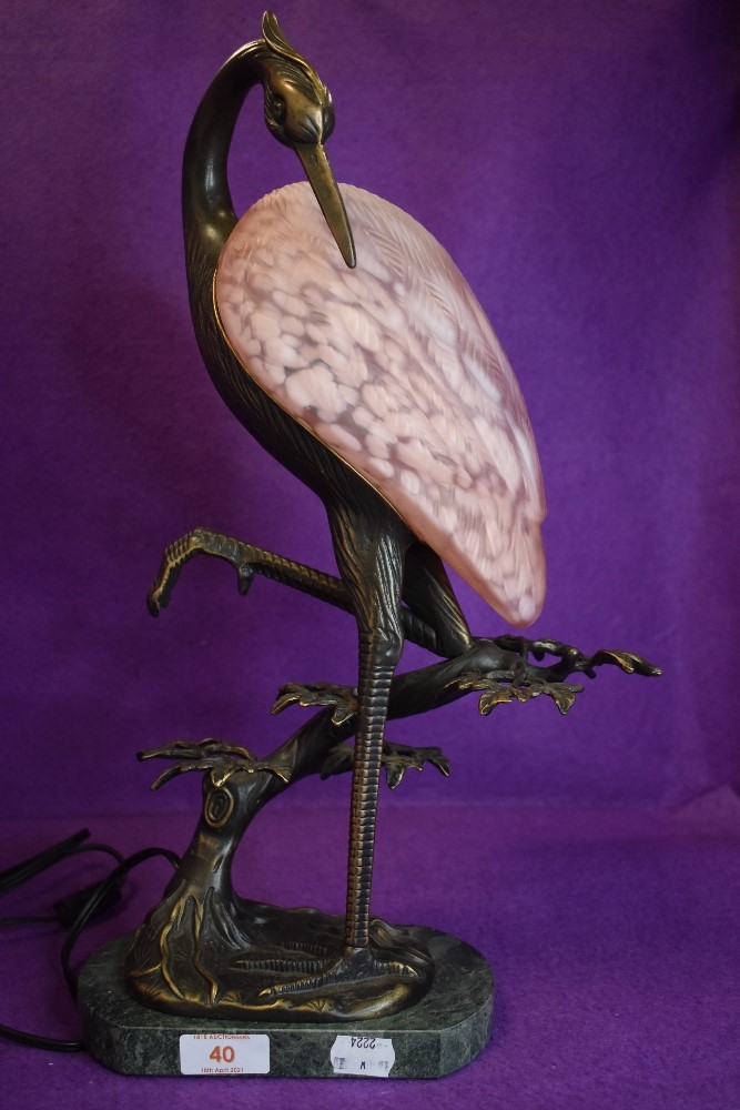 An art deco style desk lamp, wading bird with pink shade.