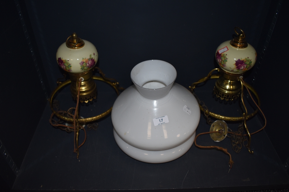 Two retro ceiling light in the form of gas lamps having floral ceramic detail and white shades.