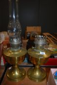 Two large brass oil lamps, one with chimney.