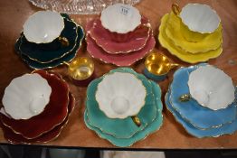 Six sets of Royal Stewart cups,saucers and side plates having scalloped edges, in block colours with