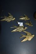 A set of five graduated brass swallows.