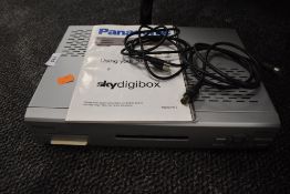 A Panasonic digital sky television box with manual.