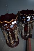 Two red glass mantle lusters with hand painted floral detail in blue with gilt accents.