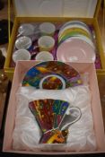 A boxed set of colourful coffee cups and similar set with cup and saucer.