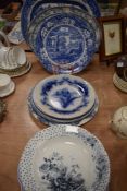 A variety of vintage and antique blue and white ware including platters and plates.