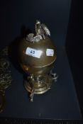 An antique plated egg poacher with bird in nest to lid.
