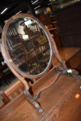 A late Victorian mahogany toilet mirror on shaped frame, veneer lifting on mirror frame, height