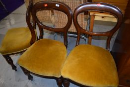 A set of three Victorian mahogany dining chairs on turned legs having later gold dralon upholstery