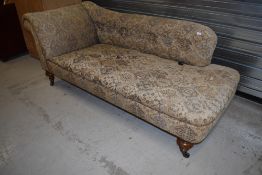 A 19th Century chaise longue, possibly later upholstery on turned mahogany legs, brass casters