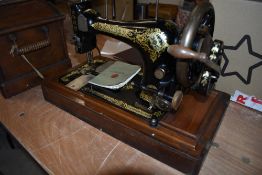 A Victorian had cranked sewing machine by Singer, with integral wooden case, serial number S323697