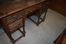 A dark oak Priory or Colonial style dressing table or desk, width approx. 122cm