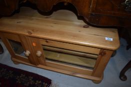 A small television stand or side cupboard in pine