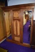 A late Victorian or Edwardian triple wardrobe, two doors being mirrored, possibly later lined,