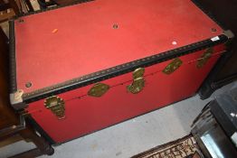 A vintage travel trunk, finished in red
