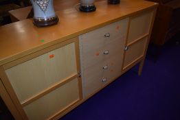 A beech effect sideboard, having four central drawers, flanked by cupboards, width approx. 137cm