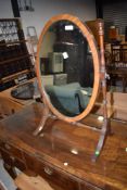 An early 20th Century oval toilet mirror on turned frame