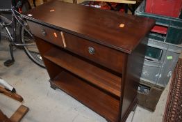 A reproduction dark stained hard wood book shelf and drawer unit
