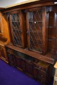 A reproduction oak dresser in the Priory style, having interesting slide top, concealing or