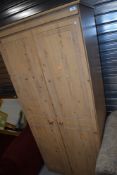 A modern pine wardrobe having carved double doors W73cm x H180cm x D51cm