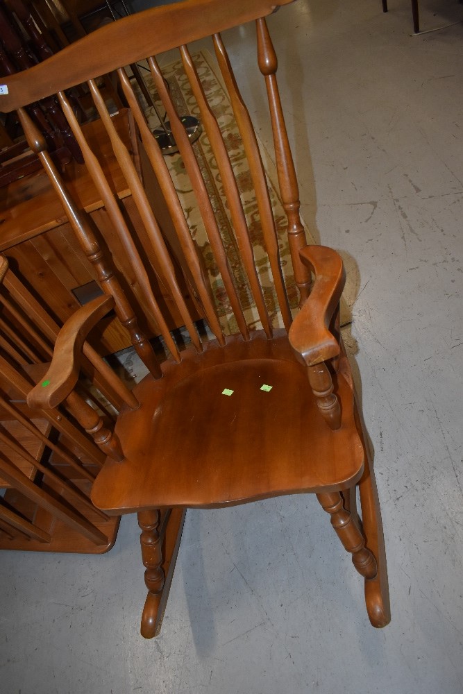 A traditional beech or rubberwood rocking armchair