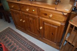 A modern pine sideboard, width approx. 140cm, having tongue and groove back and drawer bottoms