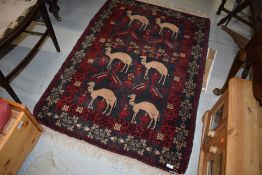 A Persian rug having red and black ground, with camel decoration, approx. 142 x 98cm