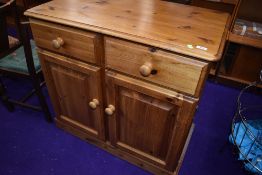 A modern pine sideboard/computer desk, having faux drawer section revealing slide out desk and