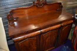 A Victorian mahogany sideboard, having ledge back, three frieze drawers, and triple cupboard