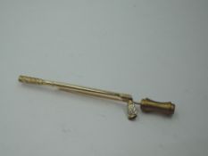 A yellow metal stick pin in the form of a golf club iron having a diamond set in the club head, no