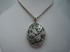 A white metal oval locket having overlaid crane decoration on a long white metal curb link chain