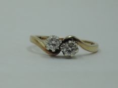 A two stone diamond cross over ring, total approx 0.25ct having crossover shoulders to a 9ct gold