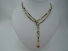 A yellow metal muff chain stamped 9C having dog leash clasp and heart charm, approx 40.5g & 35'