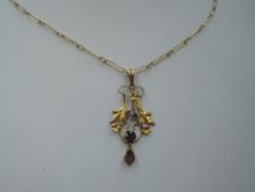 A yellow metal Edwardian style pendant stamped 9ct having purple paste stones in a foliate style