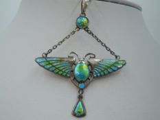 An Edwardian silver and enamel pendant in the form of a winged scarab suspended from an enamelled