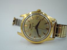 A gent's 1950/60's yellow metal wrist watch by Tissot, model Centenary, having a baton numeral