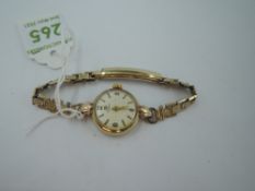 A lady's 9ct gold Tissot wrist watch having Arabic and baton numeral dial in gold case with rolled