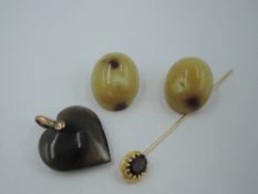 A pair of vintage horn cabouchon clip earrings having rose metal clip backs, a carved agate heart