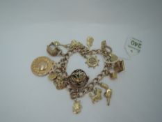 A 9ct gold charm bracelet having a padlock clasp and seventeen yellow metal and 9ct gold charms (1