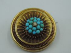 A Victorian yellow metal brooch having a turquoise and seed pearl set cluster centre within a