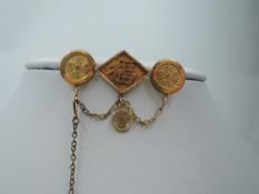 A Far Eastern yellow metal brooch stamped 18 having three panels bearing lettering, makers mark WN