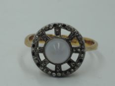 A Victorian moonstone & diamond chip cluster having an open wheel mount on an 18ct gold loop,